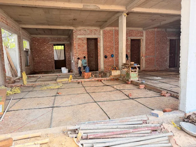 Black TermiPore porous pipe laid in a grid across a ground floor before the floor PCC is cast