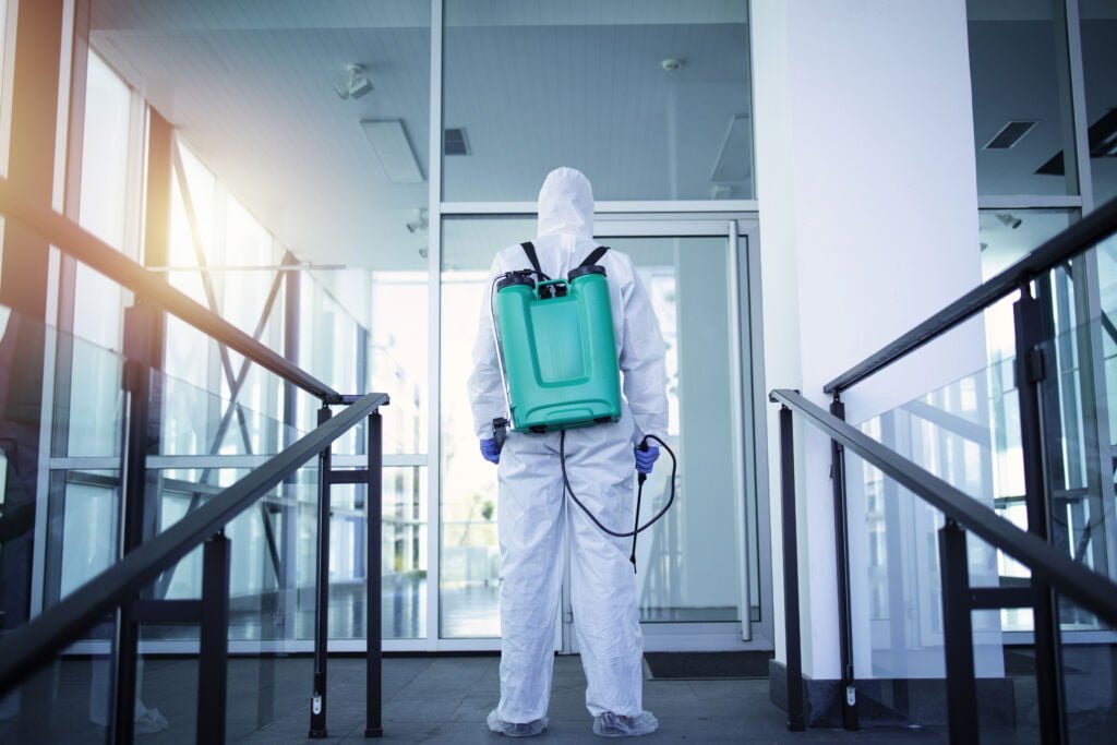 Unrecognizable person in white protection suit to make safety for public and health.